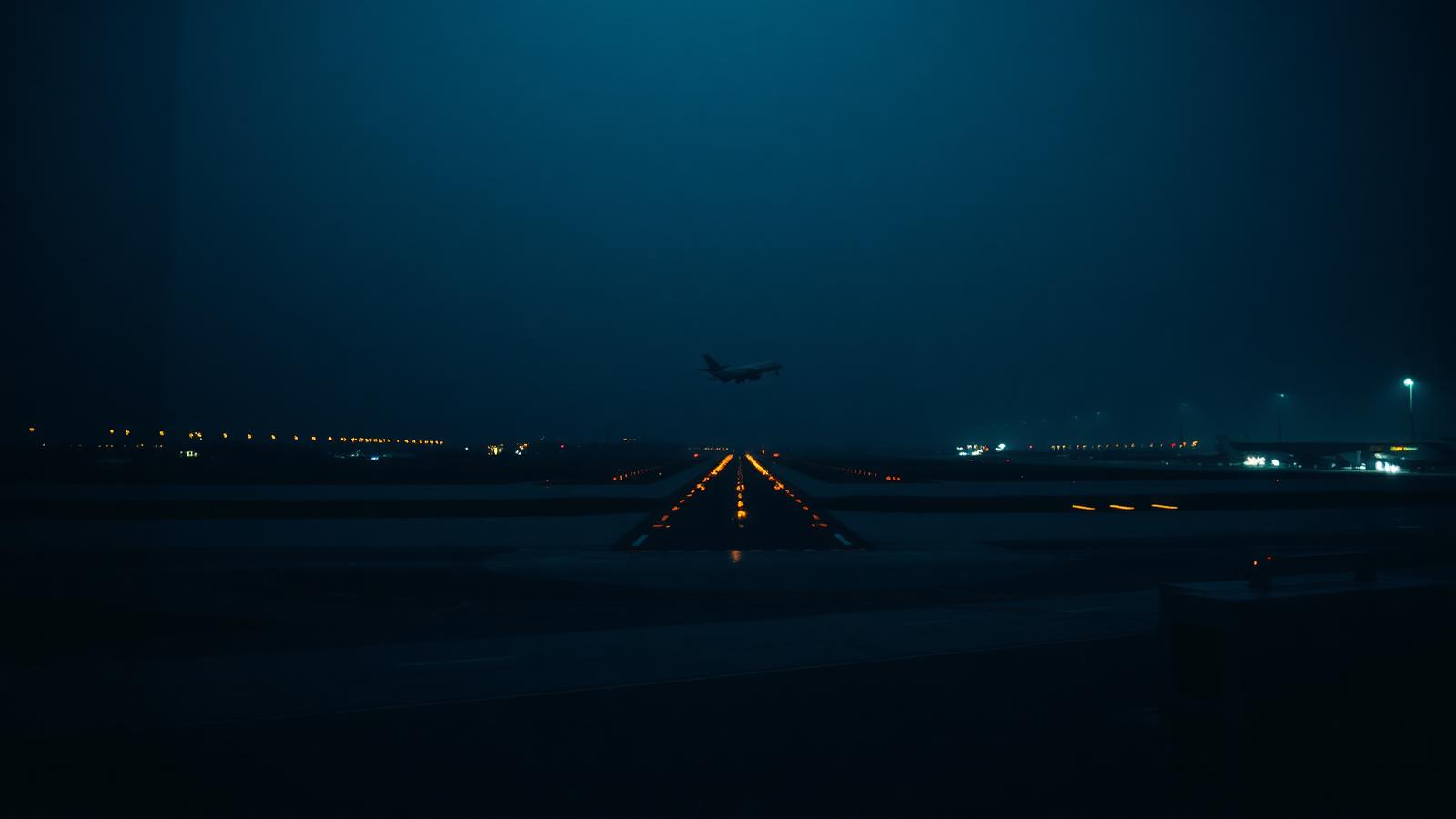 Runway lights at night seen from an airport terminal